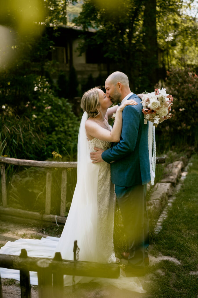 Brautpaar aus Esslingen steht auf einer Brücke und küsst sich