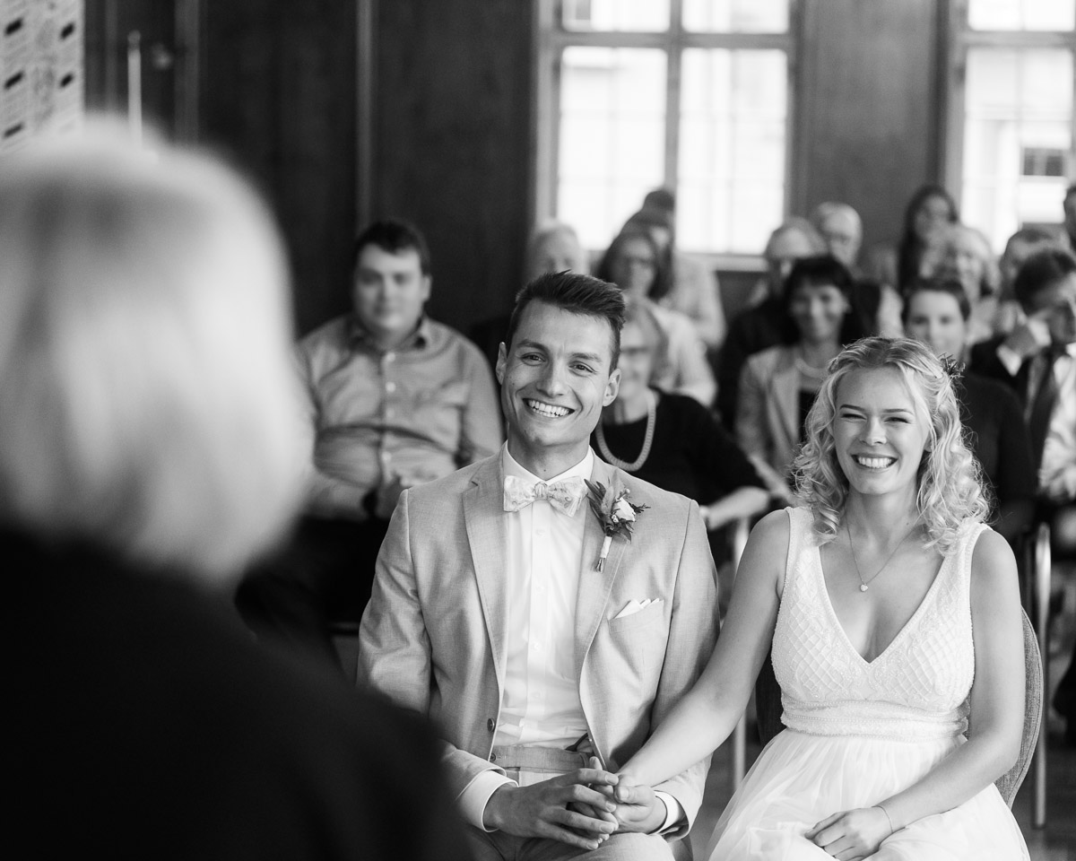Brautpaar sitzt bei der Trauung im Alten Rathaus in Esslingen und blickt auf die Standesbeamtin