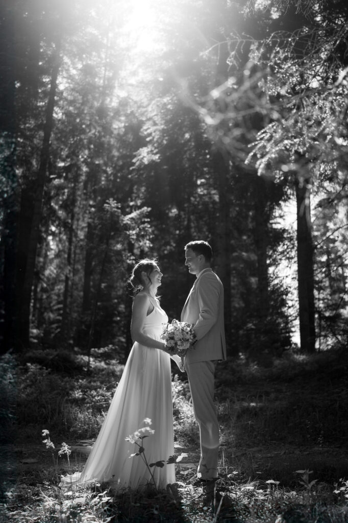 Hochzeitsfotograf Stuttgart: Brautpaar steht in einem lichtdurchfluteten Wald.