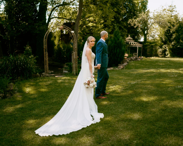 Hochzeitsreportage Stuttgart: Brautpaar läuft verträumt und Hand in Hand über einer Wiese